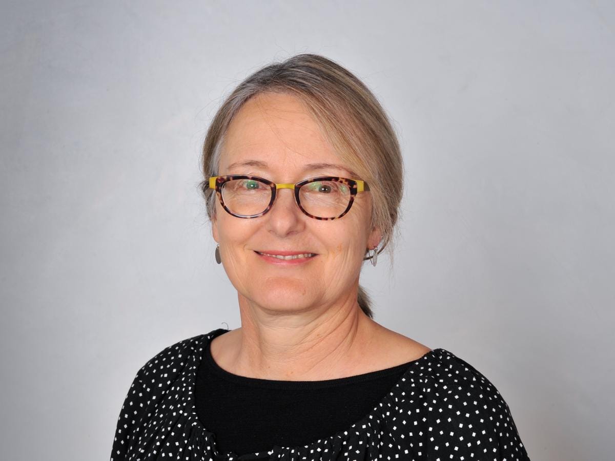 A head shot photo of Dr Fiona Mathieson on a grey background. 