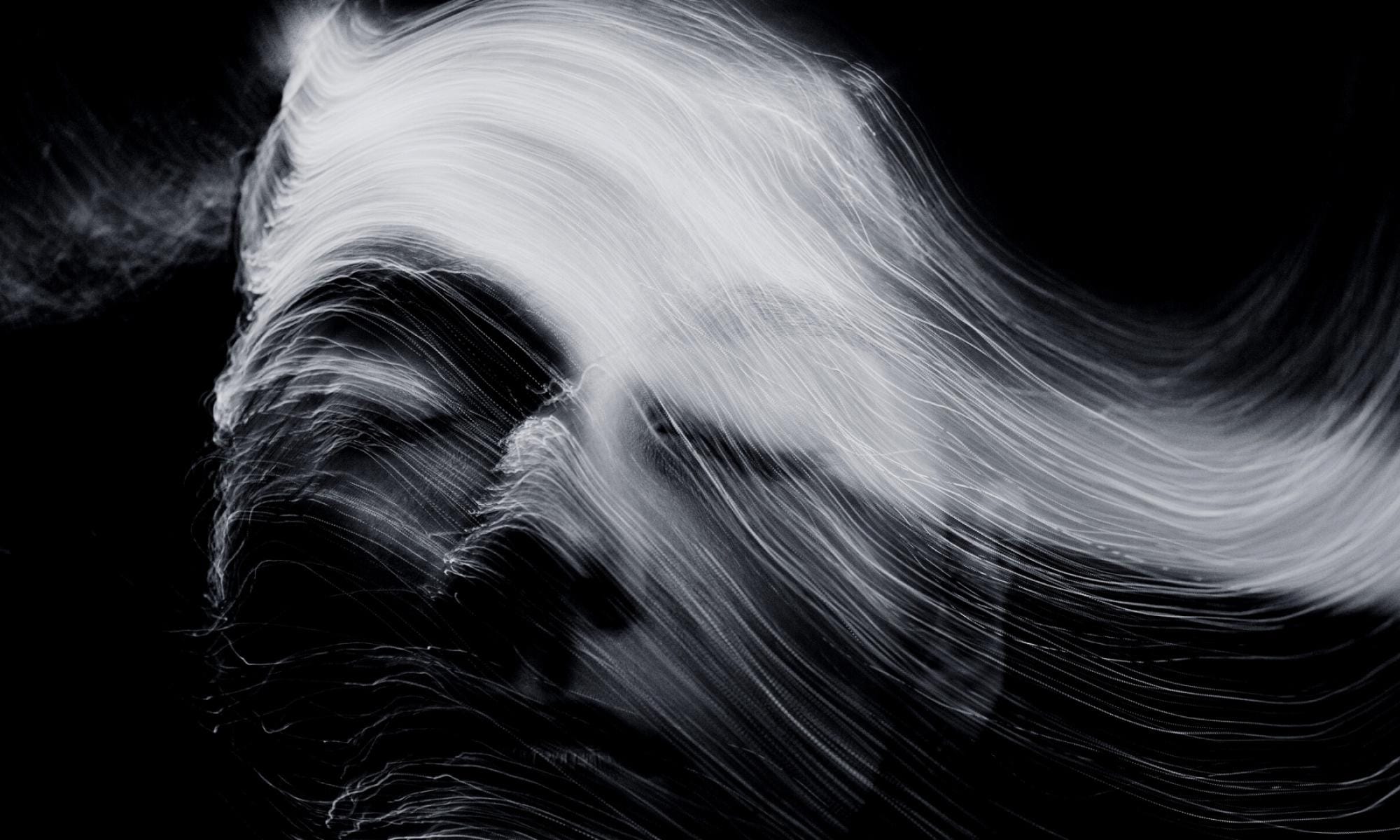 A photo of a woman with her eyes closed as smoke passes through her face.