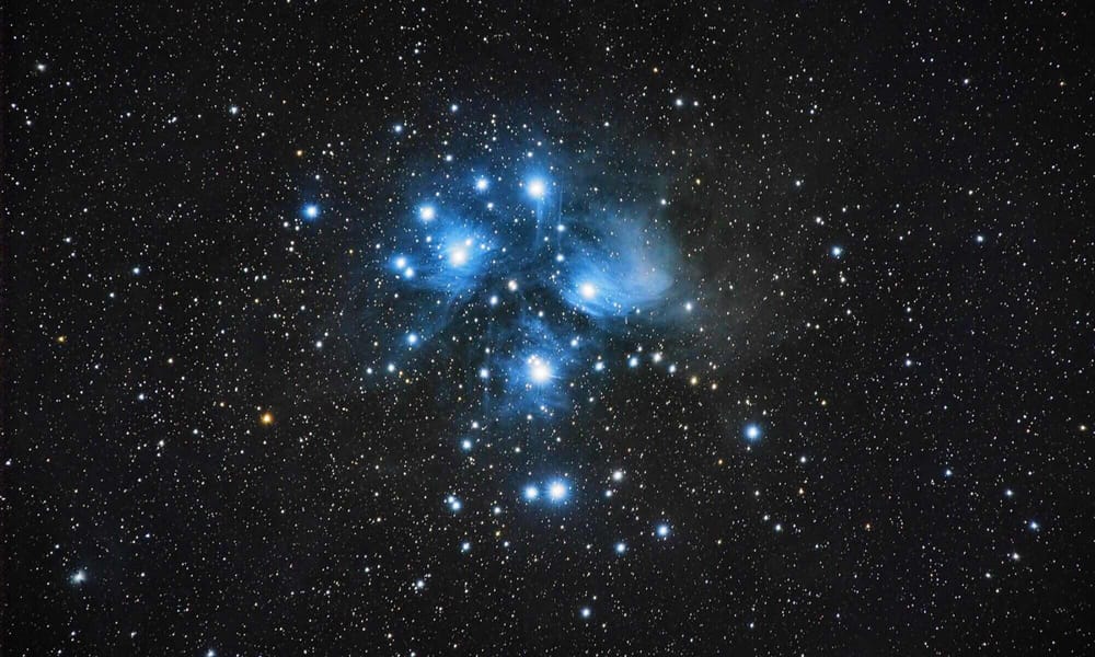 A bright picture of a night sky with some bright stars emitting a blue glow. 