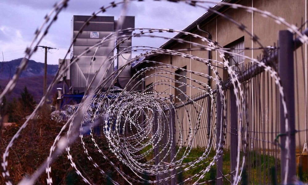 A picture of a barbed wire in a prison setting.