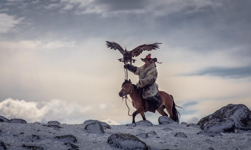 A photo of a Kazakh nomad eagle hunter with his golden eagle. 