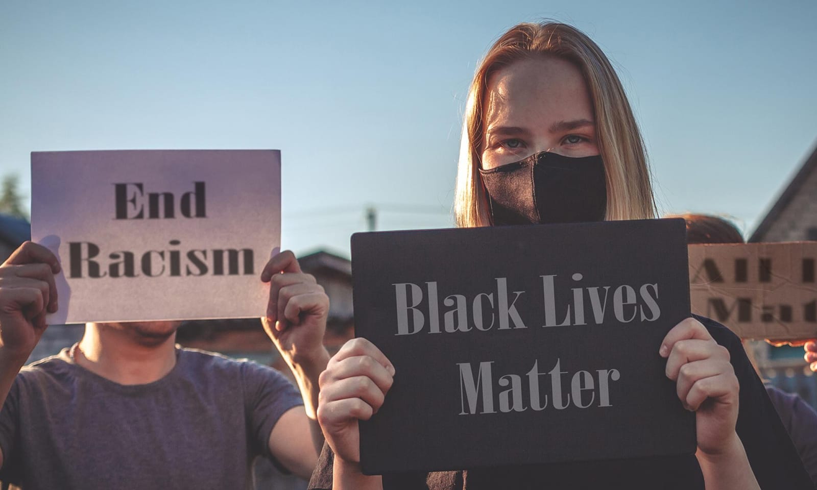 A photo of young students holding placards to protest racism. 