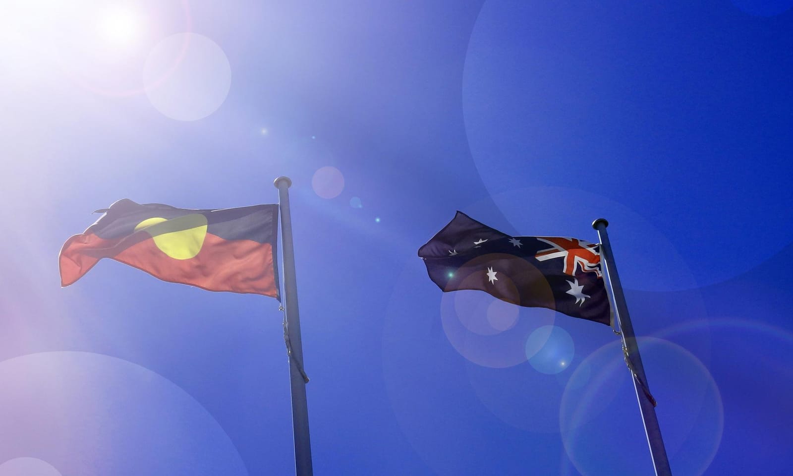 A photo of an Australian flag and an Australian Aboriginal flag.